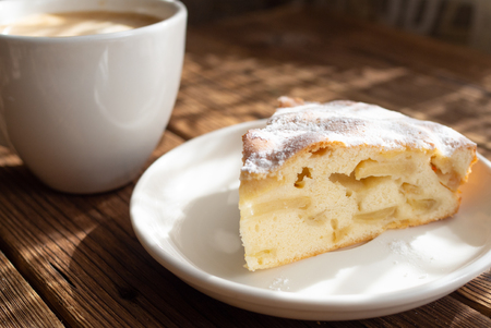 Slice of delicious apple pie on a white plate and coffeeの写真素材