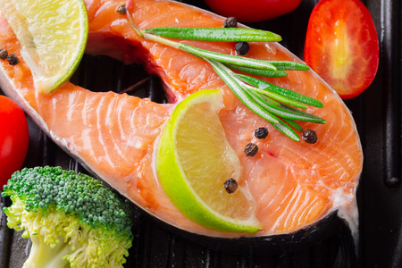 Grilled salmon steak with vegetables and spicesの写真素材