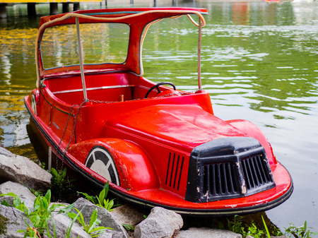 An old red pleasure boat in the form of a carの写真素材