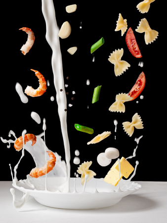 Pasta ferfalle with shrimps and creamy cheese sauce. Flying ingredients.の写真素材