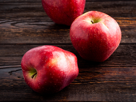 Red sweet apples on dark brown wooden background. Well suited for the catalog.の写真素材