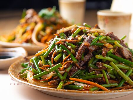 Meat in sweet and sour sauce with garlic arrows on Asianの写真素材