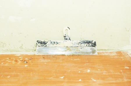 Old spatula against the  walls are covered with puttyの写真素材