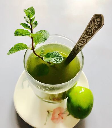 A glass of peppermint juice and a bunch of peppermint plants with lemonの素材
