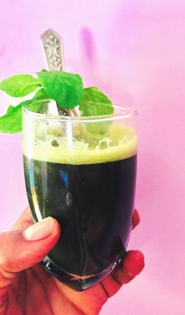 A glass of peppermint juice in the handの素材