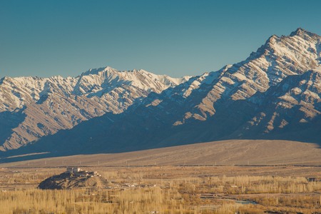 building and snow covered mountain range, Leh Ladakh, Indiaの写真素材