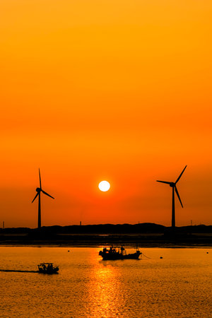 Silhouette of wind turbine at sunset,korea,selective focusの写真素材