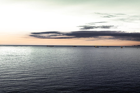 Sunset over the sea with ships in the foreground. Long exposure