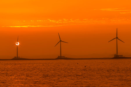Wind turbines in the sea at sunset, windmill for electric power productionの写真素材