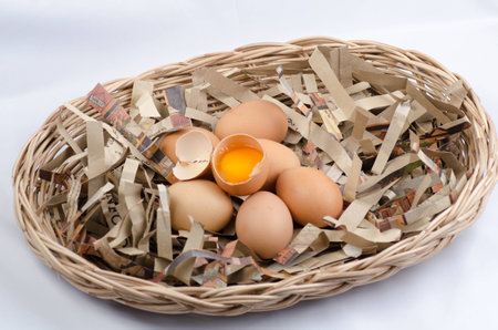 Eggs in an egg container, one of the eggs broken.の写真素材