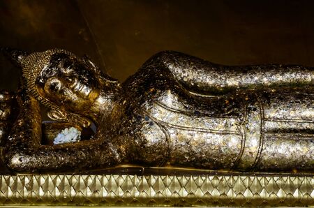 A golden reclining buddha at Wat Phranon Phetchaburi Thailand.の写真素材