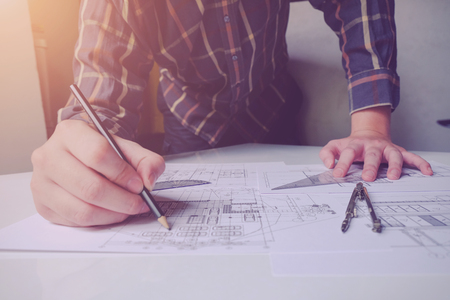Close up man working of Architect sketching a construction project on his plane project at site construction workの写真素材