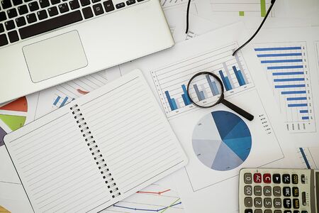 Magnifier calculator and notebook on Business report financial accounting graphs analysisの写真素材