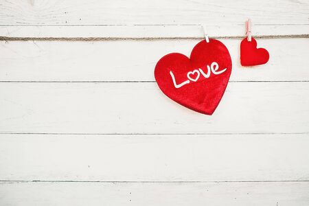 Love hearts hanging on rope on a white wooden backgroundの写真素材