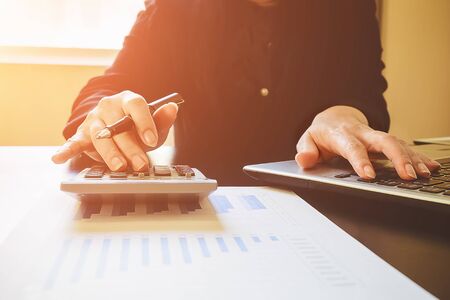 Asian Business woman using a calculator to calculate the numbers.vintage toneの写真素材