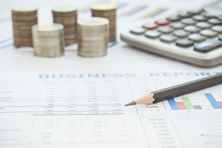 Business diagram on financial report with coins and calculatorBusiness diagram on financial report...