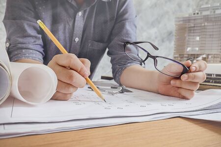 Close up man working of Architect sketching a construction project on his plane project at site construction work.の写真素材