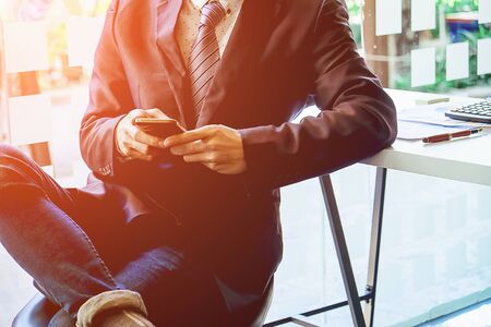 business using smartphone on table with laptop computer and graph financial with social network diagramの写真素材