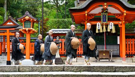 Kyoto, Japan - July 7, 2012 - Japanese monks walk through Fushimi-Inari, a shinto shrine in Kyoto. In 2011, the shrine celebrated its 1300th birthday. In the first three  days of each new year, over 3 million people flock to Fushimi-Inari for their first のeditorial素材
