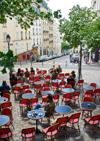 Paris Cafe - Paris, France - July 17, 2011 - Diners enjoy the sun at an outdoor cafe in Montmartre, Paris  The cafe lifestyle is a draw for the millions of tourists who visit Paris each year のeditorial素材