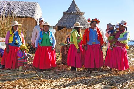 UROS ISLANDS, PERU - June 25, 2019 - Uros women on one of the Uros Islands near Puno, Peru. The islands are man-made of clay and totoro reeds and float on Lake Titicaca near the Bolivian border.のeditorial素材