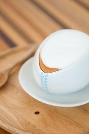 Close-up shot of white latte foam on wooden table.の写真素材