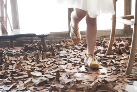 Girl legs in fashion shoes and white dress in autumn set up.の写真素材