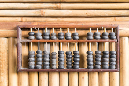 Wooden abacus on bamboo wall. Vintage calculator from asia culture.