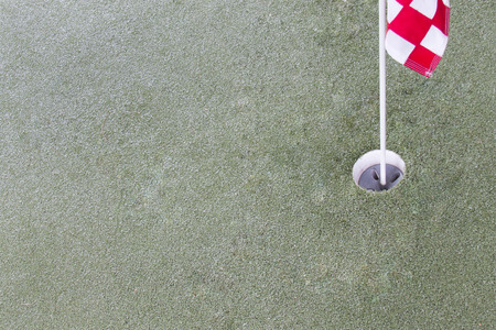Close up of golf driving range. Hole and red flag on green grass.の写真素材