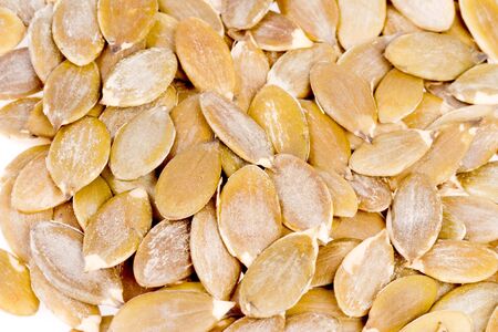 pumpkin kernels in close up on whiteの写真素材