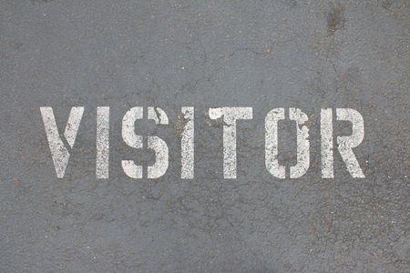VISITOR sprayed painted on a sidewalkの写真素材