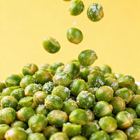 Falling frozen green peas on yellow background. Selective focus.の素材
