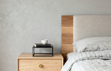 Interior of modern bedroom with wooden bedside table and coffee cupの素材