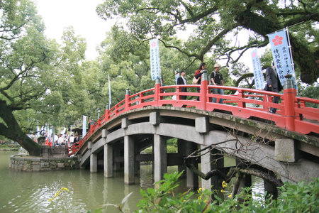 DAZAIFU, JAPAN - OCTOBER 29: People crossing the red bridge in the Japanese temple on October 29,2011, Dazaifu Japanのeditorial素材