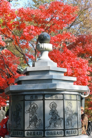 TOKYO,JAPAN - NOV 23: Red maples and the rock statue at Mt.Takao in Kanto area nearby Tokyo ,Japan on November, 23, 2011のeditorial素材