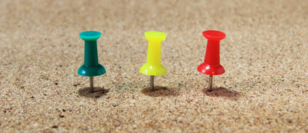 Three colors of push pins on board