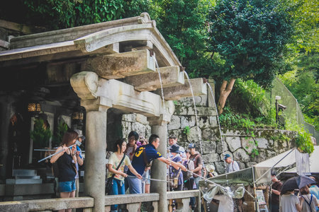 people collecting water from the Otowa-no-taki waterfall at Kiyomizu temple in Kyoto のeditorial素材