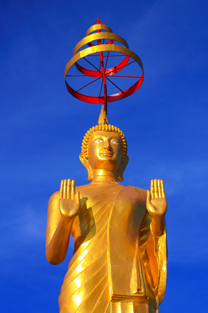 Golden big stand Buddha with blue sky in Thailand の写真素材