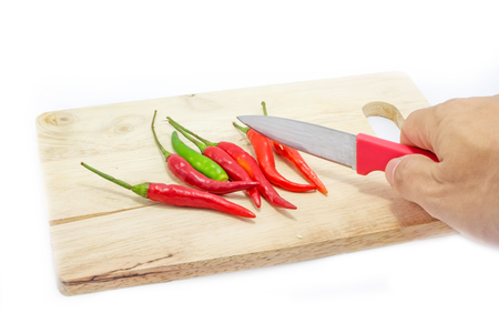 Red chili on wooden chopping board on whiteの写真素材