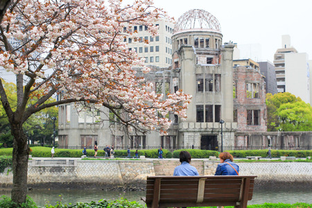 HIROSHIMA, JAPAN - April 16: Japanese people are sitting nearby the rever at the Hiroshima Peace Park in spring on April 16, 2014 in Hiroshima, Japan.のeditorial素材