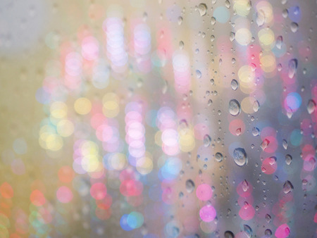 Raindrop patterns on window with night defocused lightの写真素材