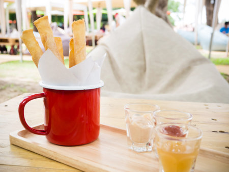 Crispy spring roll stick in a red cup