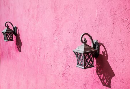 Vintage lamp hanging on the cement wall with sweet pink toneの写真素材
