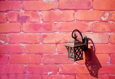 Vintage lamp hanging on the brick wall with sweet pink toneの写真素材