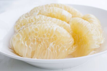 Peeled pomelo fruit on dishの写真素材
