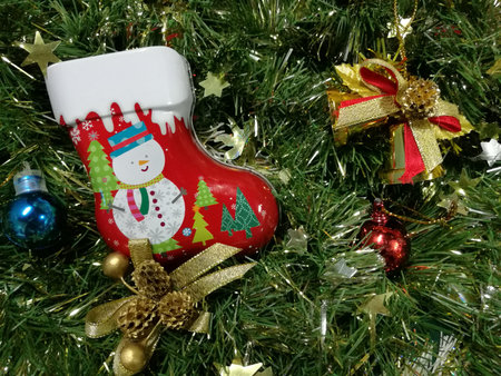 Merry Christmas and Happy New Year, snowman sock Tin Box, ribbon and ornaments decoration with green...