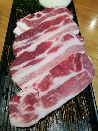 Fresh streaky pork slice serving on the tray, pork belly slice in the restaurantの写真素材
