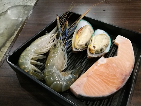 Fresh prawn , Mussel and salmon on the ice and the supermarket with blur background, Freshness Japanese seafood meat for BBQ, focus-on-foreground blur backgroundの写真素材