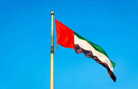 Flag of UAE or the United Arab Emirates on a flagpole flying high or waving at Love lake Al Qudra Desert Dubai. Suitable for National Day Celebration.の写真素材