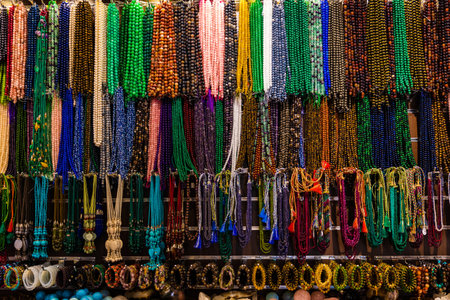 A range of colorful Handicraft bead necklaces and bangles hanging from the string in a shop. Close up shot of the colorful jewels.の写真素材